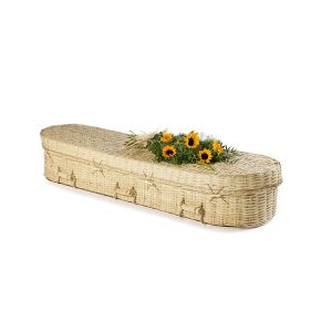 White Wicker rounded coffin with flowers on