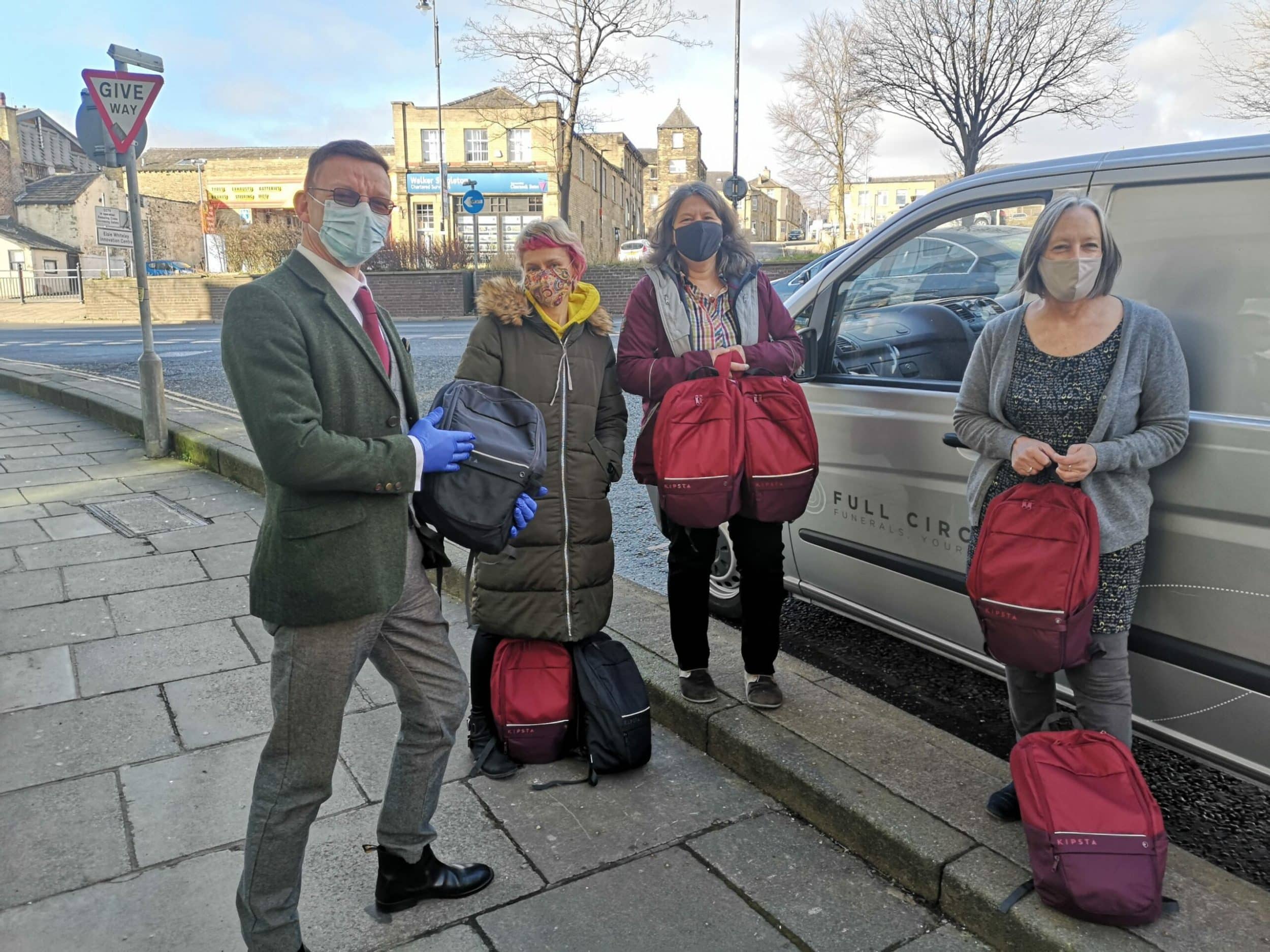 4 workers in masks outside a van