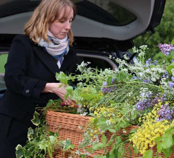 Women adding flowers to coffin